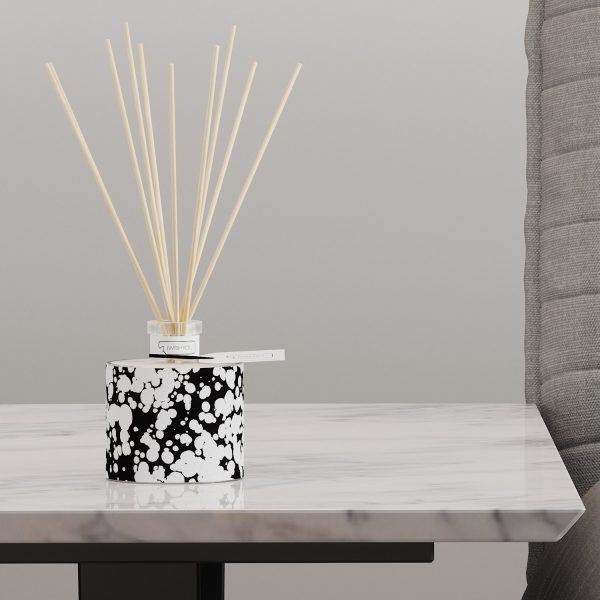 profumatore d'arredo aperto con bastoncini di bamboo poggiato su elegante tavolino moderno